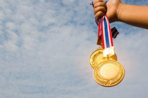girl holding up gold medals