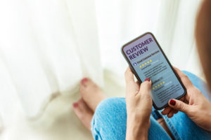 Female sitting in house to Reading Customer Review in SmartPhone