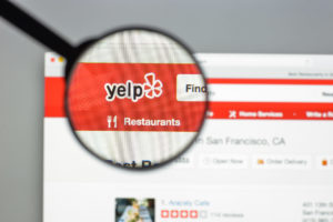 Yelp website homepage with magnifying glass looking at the logo