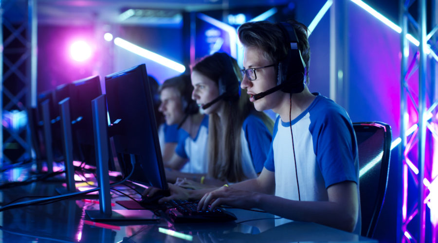 Team of Teenage Gamers Play in Multiplayer PC Video Game on a eSport Tournament.